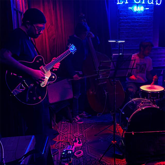 Picture of Pablo Cúbico, founder of Music Teacher Studio, playing guitar in a jazz club.